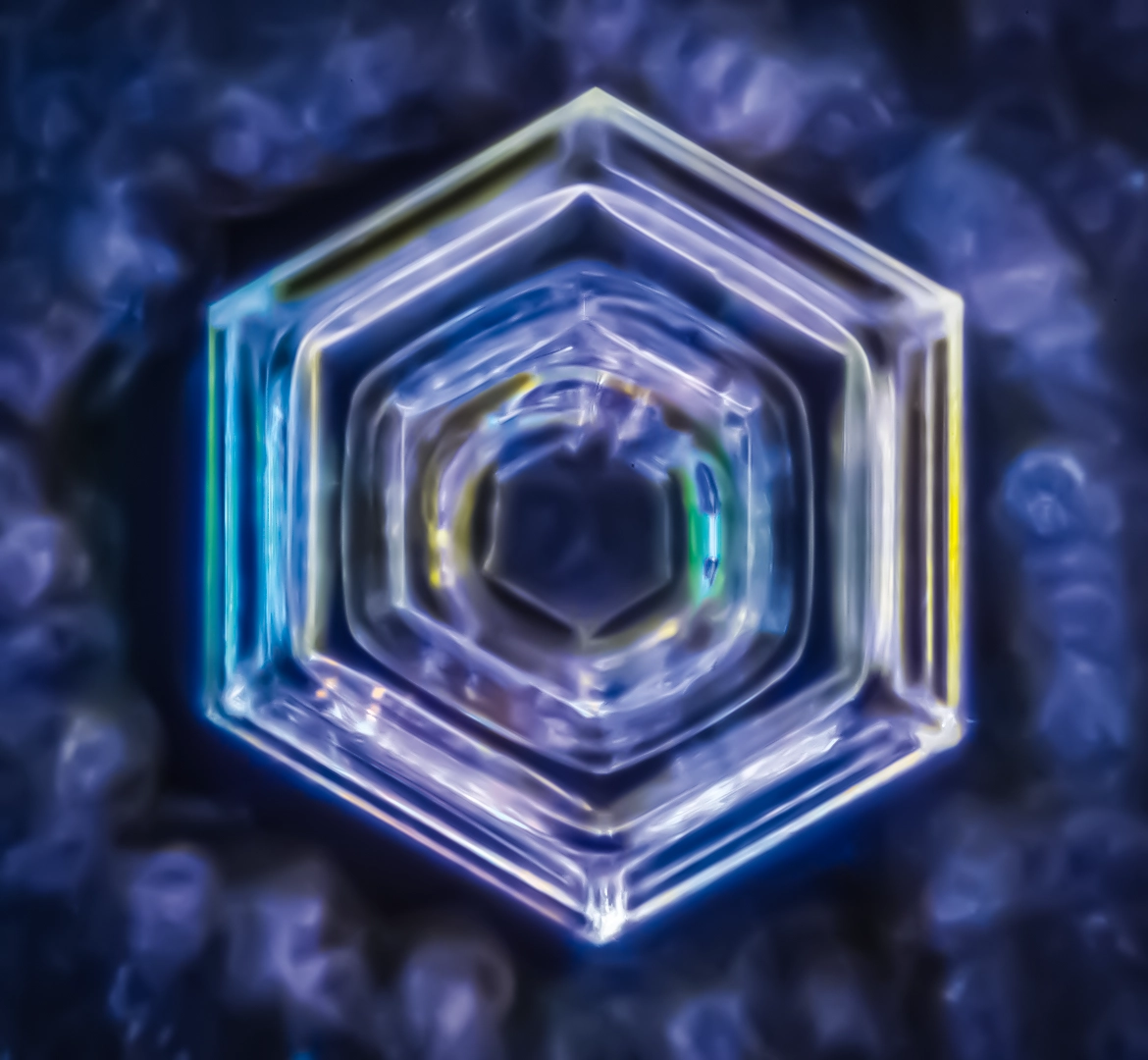 Photographie microscopique de cristal d'eau révélant la géométrie sacrée de l'eau. Inspiré des travaux de Masaru Emoto et Marc Henry sur la mémoire de l'eau, ce cristal témoigne de l'influence des vibrations positives sur la structure moléculaire. Physique quantique et conscience cristallisée.